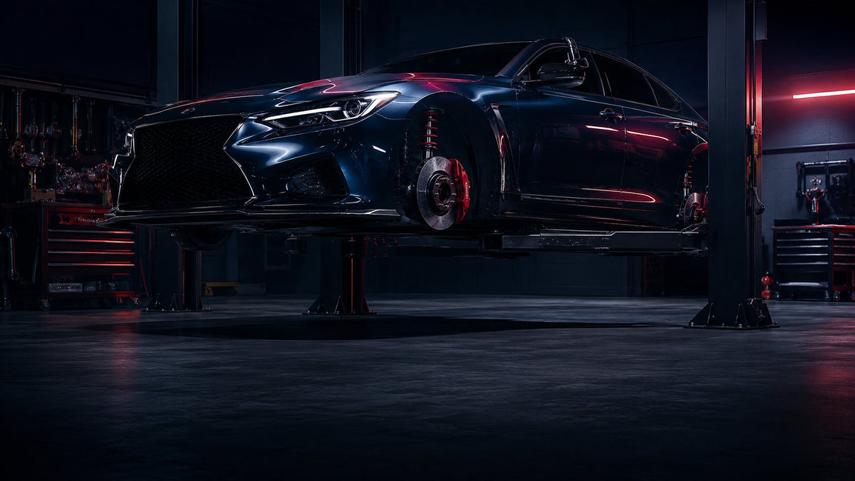 Performance sedan on lift in workshop showcasing suspension and brake system