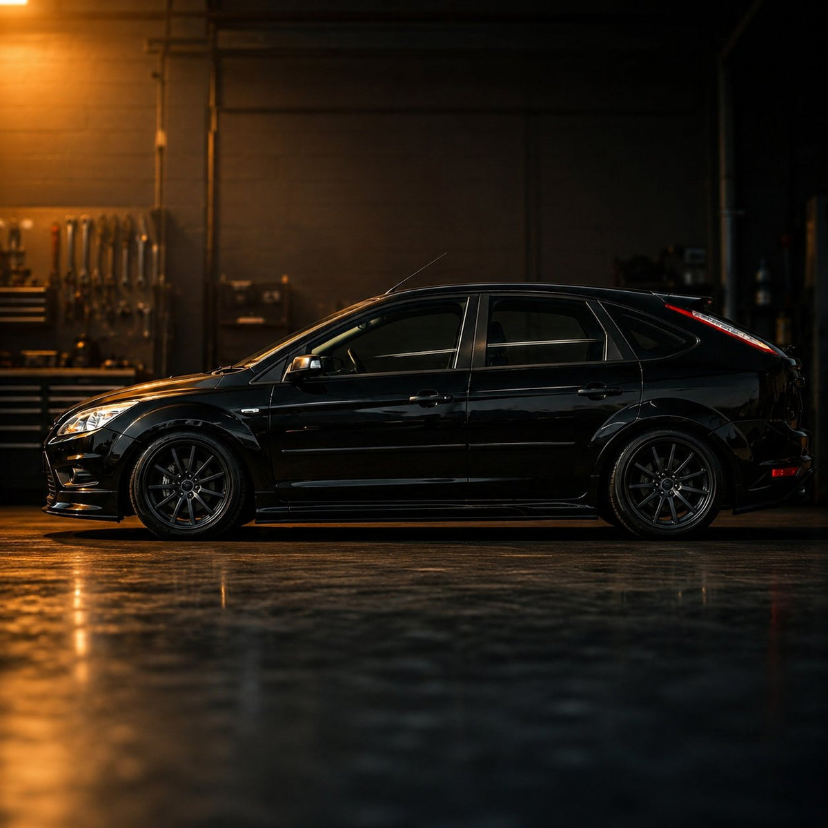 Black Ford Focus side profile in moody workshop for VREL About Us community section